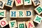 Alphabet block in word  HRD Abbreviation of human resource development with another on wood background