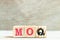 Alphabet block in word MOQ Abbreviation of Minimum Order Quantity on wood background