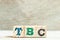 Alphabet block in word TBC Abbreviation of to be confirmed or continued on wood background