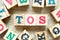 Alphabet block in word TOS abbreviation of Terms of service with another on wood background