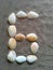 Alphabet character G created with seashells on beach-sand