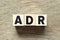 Alphabet letter block in word ADR Abbreviation of adverse drug reaction on wood background