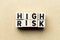 Alphabet letter block in word high risk on wood background