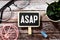 Alphabet letter in word ASAP Abbreviation of as soon as possible on wood background