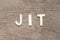 Alphabet letter in word JIT abbreviation of just in time on wood background