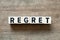 Alphabet letter in word regret on wood background