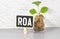 Alphabet letter in word ROA Abbreviation of Return on assets on wood background