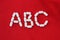 Alphabet made of pills on a red background. Abc from drugs. Vitamins White pills without an inscription. generics, pharmacy and m