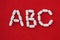 Alphabet made of pills on a red background. Abc from drugs. Vitamins White pills without an inscription. generics, pharmacy and m