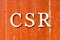 Alphabet in word CSR Abbreviation of corporate social responsibility on old red color wood plate background