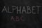 Alphabet word and first three letters on black chalkboard