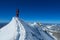 Alpine climber on sharp knife-edged snow mountain ridge