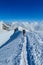 Alpine climber on sharp knife-edged snow mountain ridge