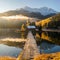 Alpine dawn serenade: Lake, snowy peaks, and the charm of autumn trees.