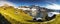 Alpine lake in autumn with wooden cabins. Snow in the mountains by a beautiful lake