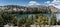 An alpine lake with trees, mountains and dramatic clouds on a sunny day