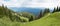 Alpine landscape at Brauneck mountain, with green pasture and forest, cloudy sky bavaria