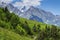 Alpine landscape of green meadow and rocky mountains in a clear sunny summer day. Amazing rural mountain scene hills