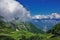 Alpine landscape in summer. In the valley there is green vegetation