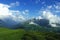 Alpine meadows, mountains and lots of white clouds with beautiful summer landscape