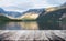 Alpine mountain range with lake in summer with wooden patio