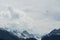 Alpine peaks landscape in early spring with a para-glider flying above.