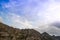 Alpine range on horizon. Structure of rocks with stones on slope. Silhouette of mountain line