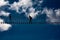 Alpine rope suspension bridge with a person against blue sky