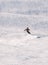 Alpine skier on a steep downhill slope at a winter sports resort