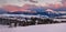 Alpine village outskirts panorama in last evening sunset sun light. Winter snowy hills and fir trees, magnificient and picturesque