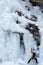 Alpinist climbing an icefall in Val D`Aosta, Italy