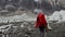 Alpinist with red backpack walk on rocky path along glacial to Everest Base Camp