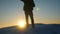 Alpinist travels hiking. A traveler descends on a snowy mountain from top, in sunset light. tourist goes to victory