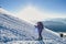 Alpinist traversing a snow slope high in the mountains