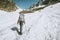 Alpinist woman with backpack climbing to the top of mountain