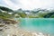 Alps landscape - glacial lake in front of mountains and blue sky