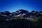 Alps mountain meadow tranquil summer view. Landscape with fog in mountains and rows of trees