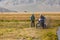 Altai, Mongolia - June 14, 2017: Mongolian nomad looks at tourists wich motorcycle stuck in mud