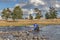 Altai, Mongolia - June 14, 2017:A motorcyclist pushes a motorcycle along a road flooded with water. Altai, Mongolia