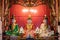 Altar with three sitting statues at a viet temple. Spirits of three deities. Red wooden background. Golden details. Pagoda VÄ©nh