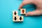 Alternative business development concept - hand holds wooden cube with red arrow