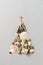 Alternative Christmas tree made from seashells and with a red starfish on a light gray background.