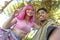 Alternative diverse couple hanging out together chilling and smiling sitting in a park posing and taking a pov selfie portrait.