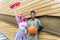 Alternative diverse couple hanging out together chilling and smiling standing against background wall. happy interracial friends