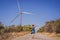 Alternative energy, wind farm and happy time with your family. Happy woman on the road on vacation and escape to nature