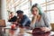 Alternative girl with green hair is sitting against group of multi ethnic people that working together by the table