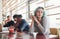 Alternative girl with green hair is sitting against group of multi ethnic people that working together by the table