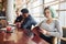 Alternative girl with green hair is sitting against group of multi ethnic people that working together by the table