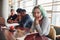 Alternative girl with green hair is sitting against group of multi ethnic people that working together by the table