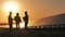 Alternative, green energy worker. Three solar energy specialists inspecting a solar power plant at sunset